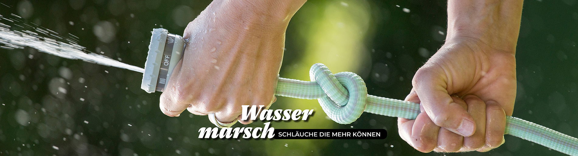zwei Hände halten einen Wasserschlauch der trotz Knoten Wasser spritzt